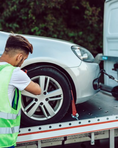 Handsome middle age man working in towing service on the road. Roadside assistance concept.