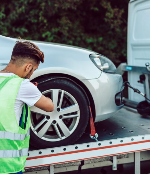 Handsome middle age man working in towing service on the road. Roadside assistance concept.